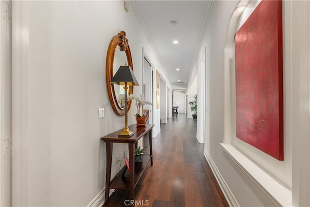 hall with dark wood-type flooring and ornamental molding