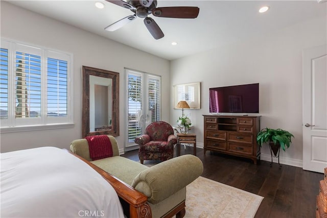 bedroom featuring ceiling fan, multiple windows, and dark hardwood / wood-style flooring