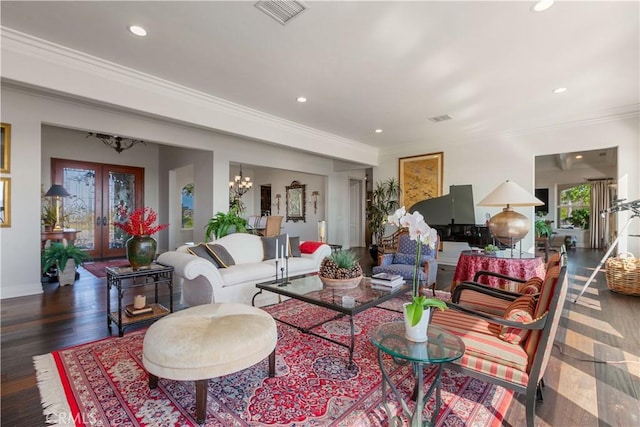 living room with french doors, dark hardwood / wood-style floors, an inviting chandelier, and ornamental molding