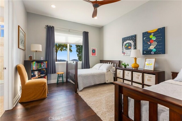 bedroom featuring ceiling fan, dark hardwood / wood-style floors, and connected bathroom