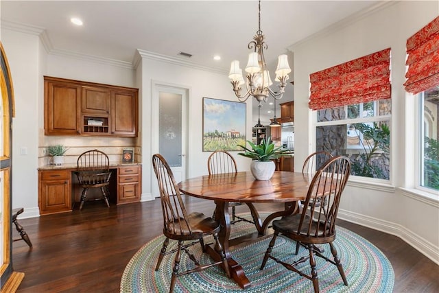 dining space with a chandelier, ornamental molding, and dark hardwood / wood-style flooring