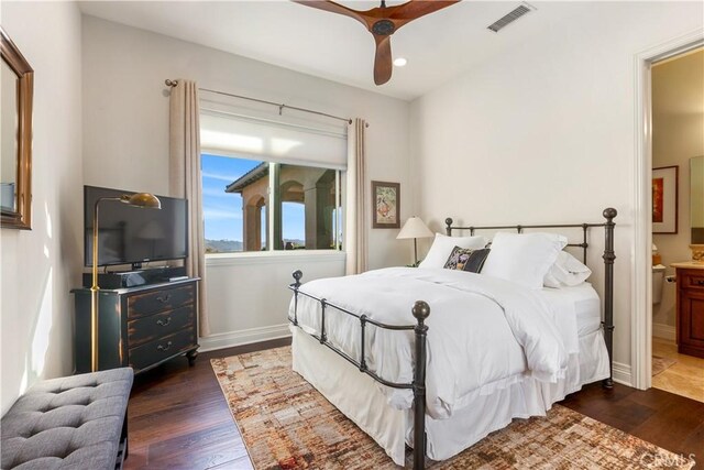 bedroom featuring ceiling fan, dark wood-type flooring, and connected bathroom