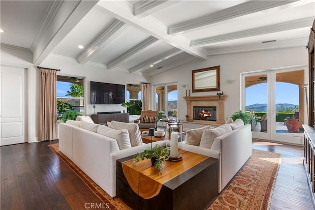 living room featuring dark hardwood / wood-style floors, vaulted ceiling with beams, and ceiling fan