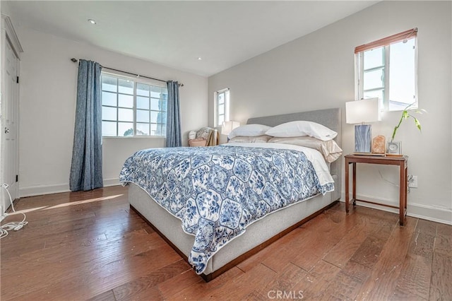 bedroom featuring dark hardwood / wood-style flooring and multiple windows