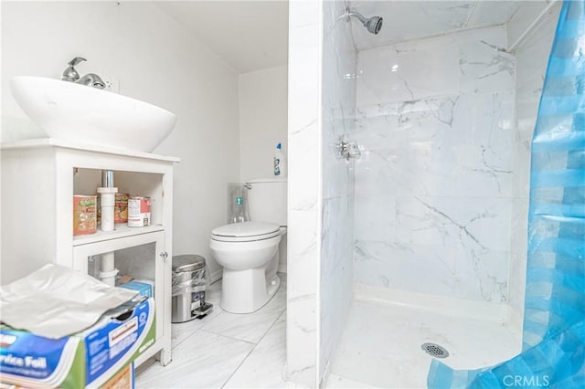 bathroom featuring a tile shower and toilet