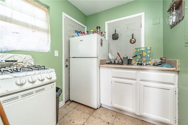 kitchen featuring white cabinets and white appliances