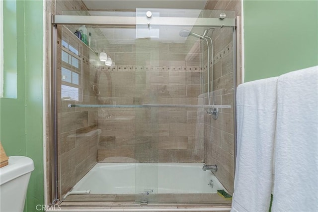 bathroom with toilet and enclosed tub / shower combo