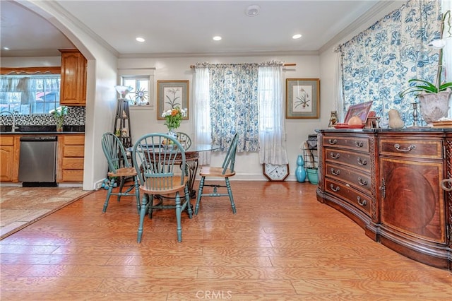 dining area with light hardwood / wood-style flooring and crown molding