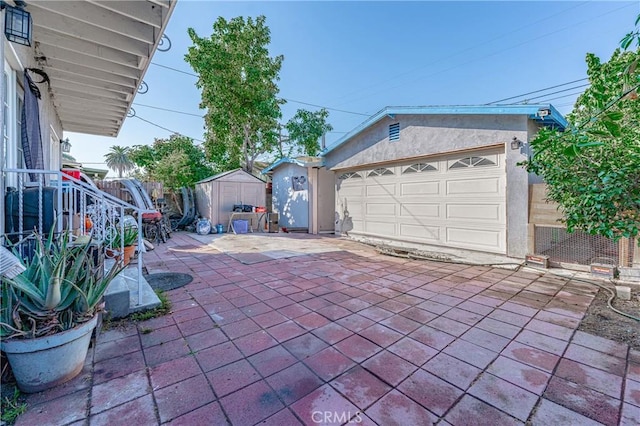 view of patio / terrace featuring a garage and a storage shed