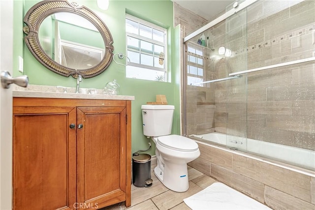 full bathroom with tile patterned flooring, vanity, toilet, and shower / bath combination with glass door