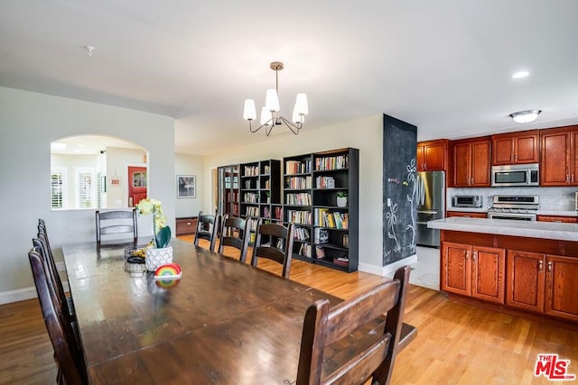 dining space featuring light hardwood / wood-style floors and a notable chandelier