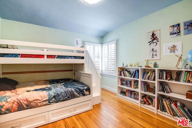 bedroom featuring vaulted ceiling and light hardwood / wood-style flooring