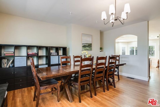 dining room featuring light wood-type flooring and an inviting chandelier