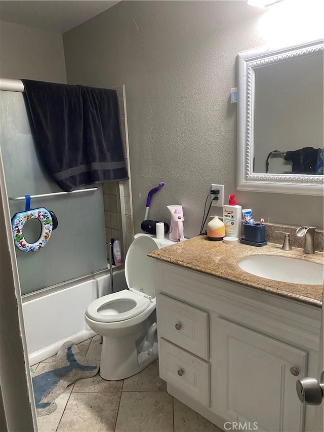 full bathroom with toilet, tile patterned floors, vanity, and shower / bath combination with glass door