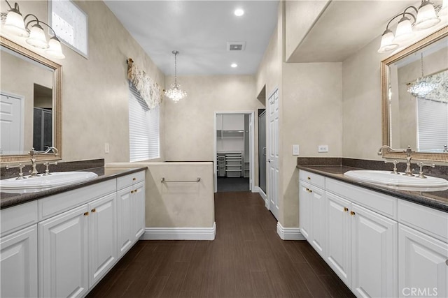 bathroom with hardwood / wood-style floors, vanity, and a chandelier