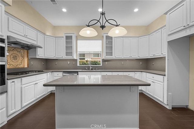 kitchen with white cabinets, black gas cooktop, a kitchen island, and hanging light fixtures