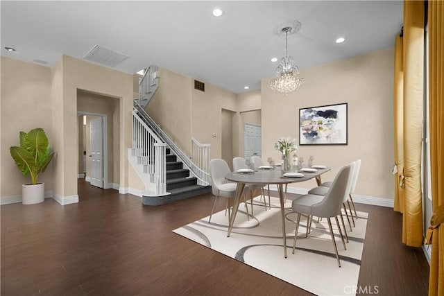 dining room with dark wood-type flooring and a notable chandelier