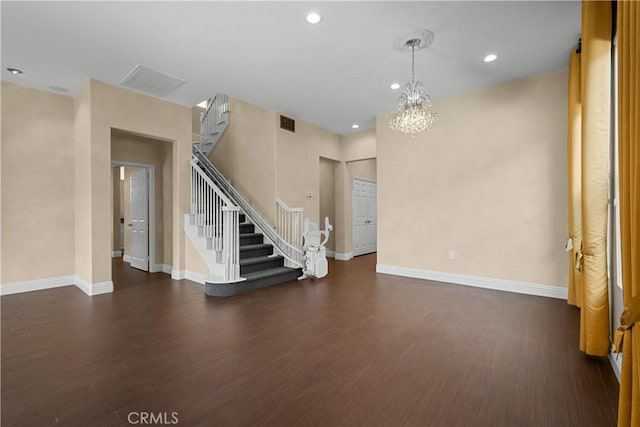 unfurnished living room with dark wood-type flooring and a notable chandelier