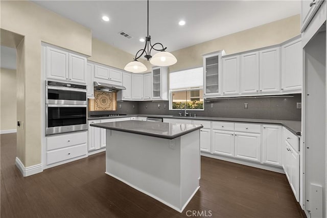 kitchen with white cabinets, pendant lighting, stainless steel double oven, and dark wood-type flooring