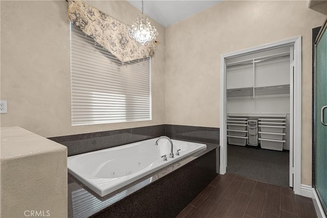 bathroom featuring hardwood / wood-style floors, shower with separate bathtub, and a notable chandelier