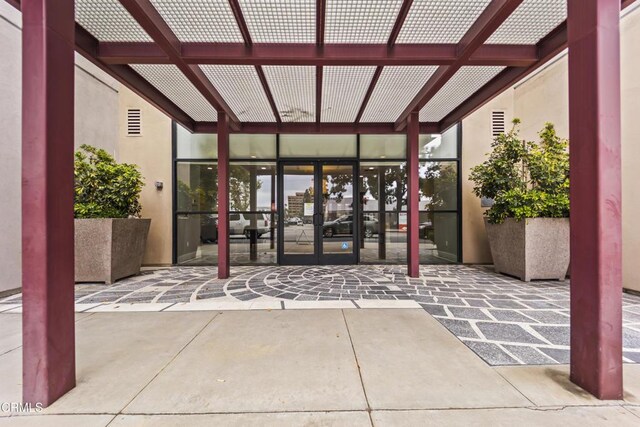 doorway to property featuring french doors, a pergola, and a patio