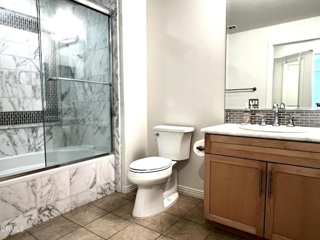 full bathroom with shower / bath combination with glass door, tile patterned flooring, vanity, backsplash, and toilet