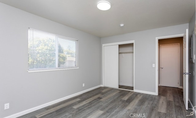 unfurnished bedroom featuring a closet and dark hardwood / wood-style flooring