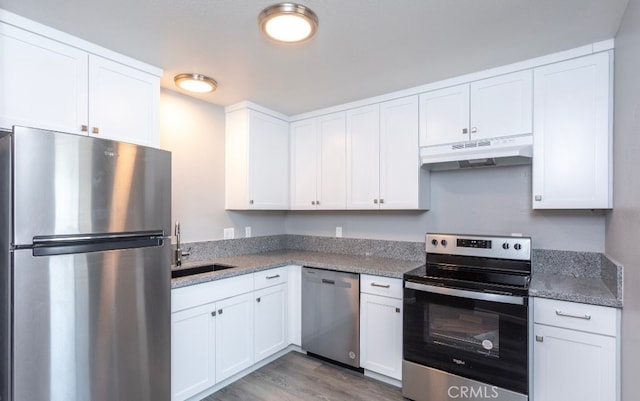 kitchen featuring sink, hardwood / wood-style floors, appliances with stainless steel finishes, and white cabinetry