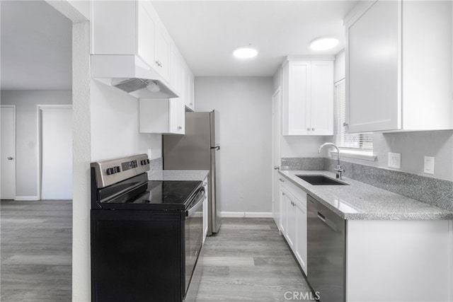 kitchen with sink, appliances with stainless steel finishes, light wood-type flooring, and white cabinets