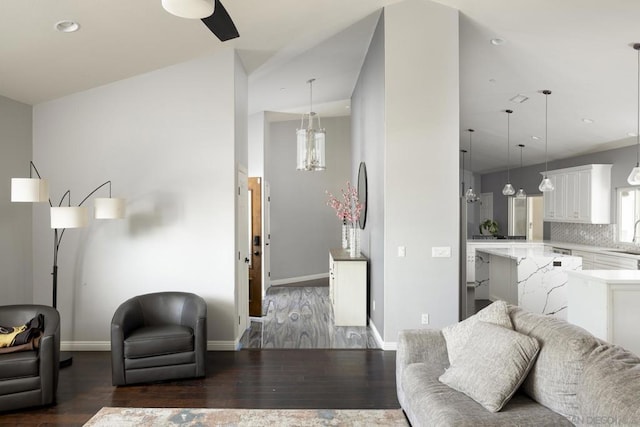 living room with lofted ceiling, dark hardwood / wood-style flooring, and sink