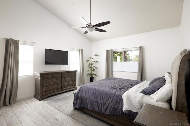 bedroom with ceiling fan, light hardwood / wood-style floors, and high vaulted ceiling