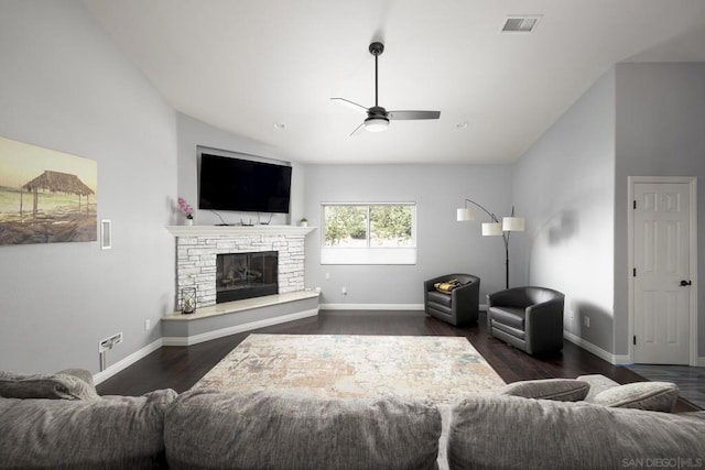 living room featuring ceiling fan, dark hardwood / wood-style floors, a stone fireplace, and high vaulted ceiling