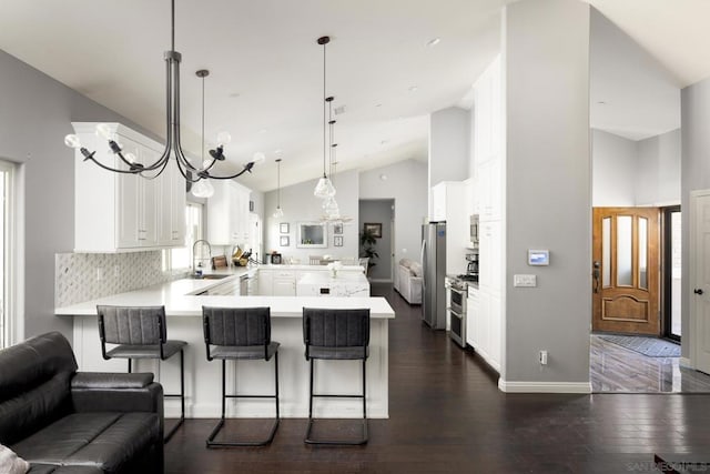 kitchen with a kitchen bar, kitchen peninsula, backsplash, a notable chandelier, and decorative light fixtures