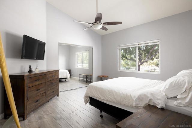 bedroom featuring ceiling fan, a closet, light hardwood / wood-style floors, and lofted ceiling