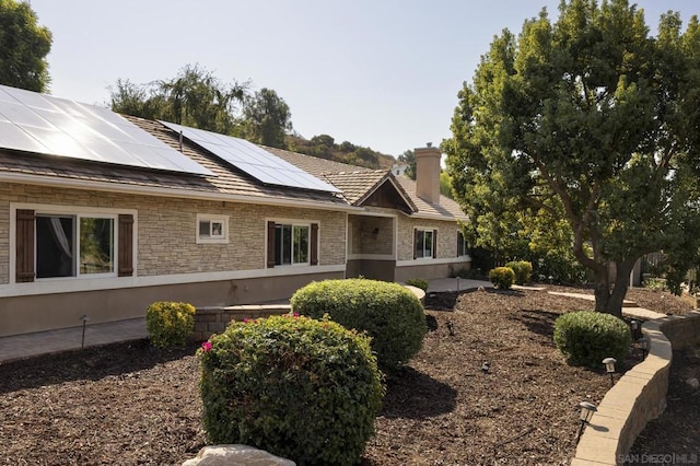 view of side of home featuring solar panels