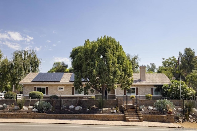 ranch-style home featuring solar panels