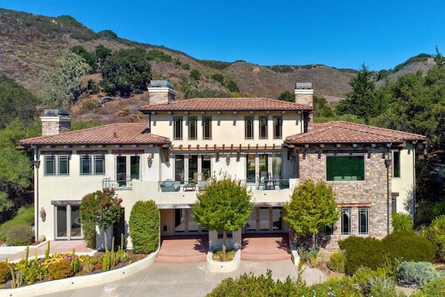 view of front of house featuring a mountain view and a balcony