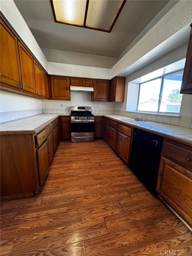 kitchen featuring sink, dishwasher, dark hardwood / wood-style flooring, and stainless steel stove