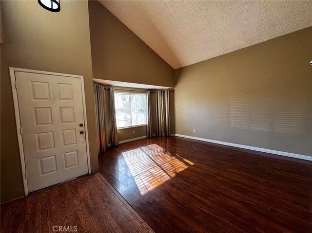 foyer with high vaulted ceiling, a textured ceiling, and dark hardwood / wood-style flooring