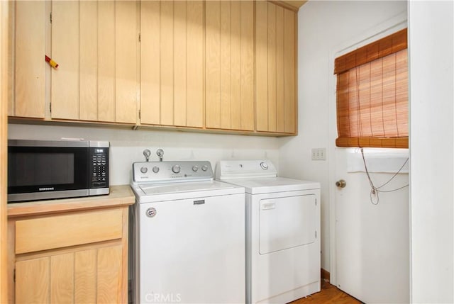 laundry room with cabinets, separate washer and dryer, and light hardwood / wood-style flooring