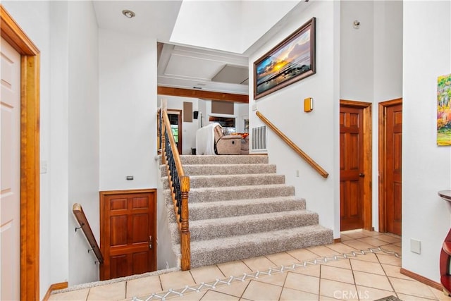 staircase featuring tile patterned floors and a towering ceiling