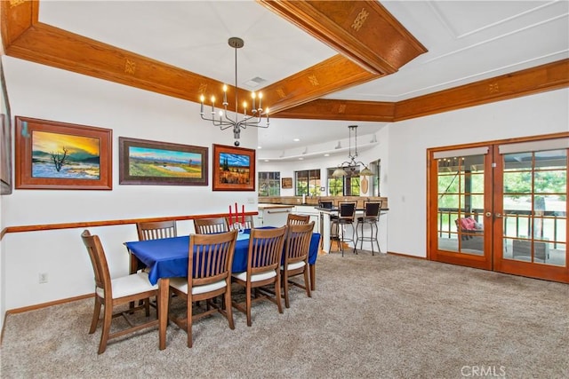 carpeted dining room with french doors, a notable chandelier, and crown molding