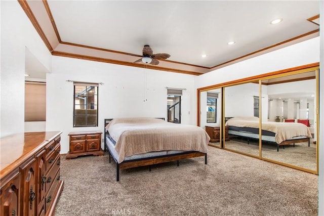 bedroom with ceiling fan, carpet, crown molding, and a closet