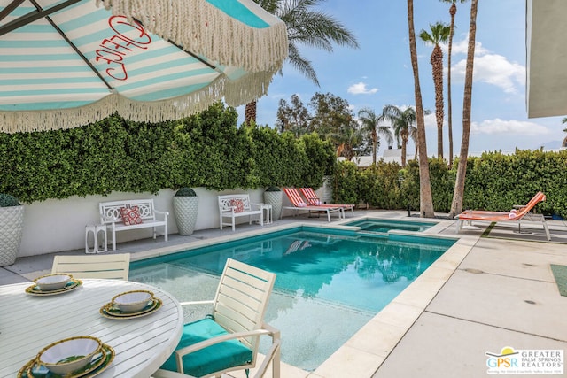 view of pool with an in ground hot tub and a patio