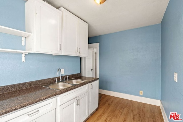 kitchen featuring light hardwood / wood-style floors, white cabinetry, and sink