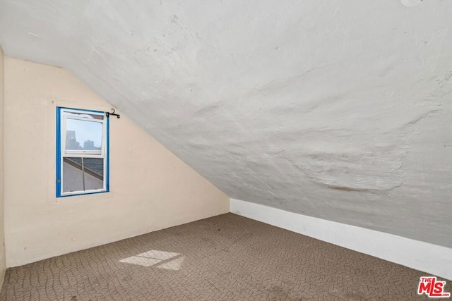 additional living space featuring carpet floors and lofted ceiling