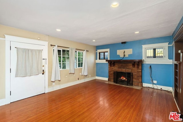 unfurnished living room with a fireplace and hardwood / wood-style floors