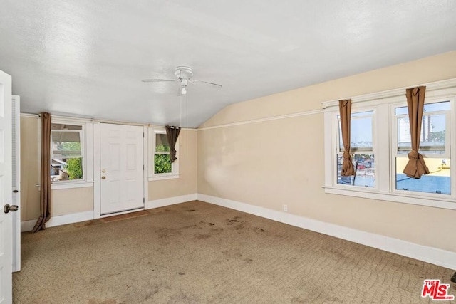 foyer with carpet flooring, ceiling fan, and vaulted ceiling