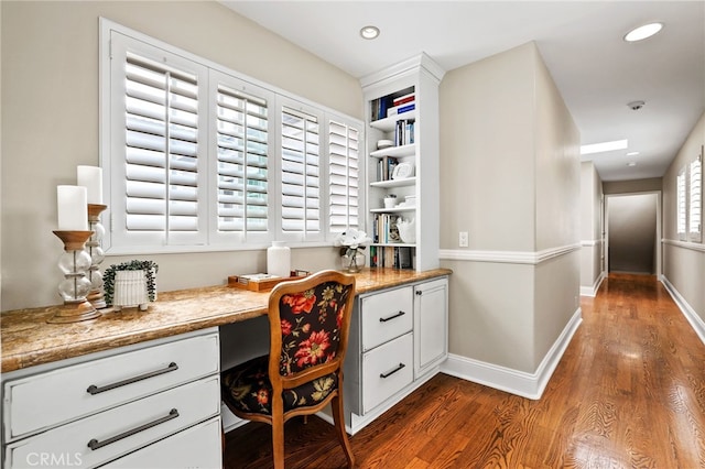 office area featuring dark hardwood / wood-style flooring and built in desk