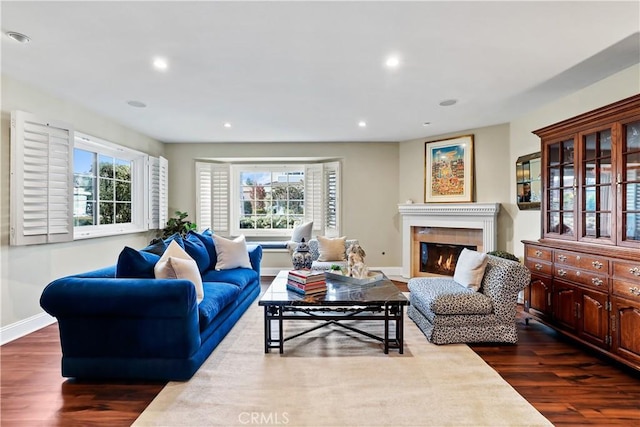 living room with dark wood-type flooring and a tile fireplace